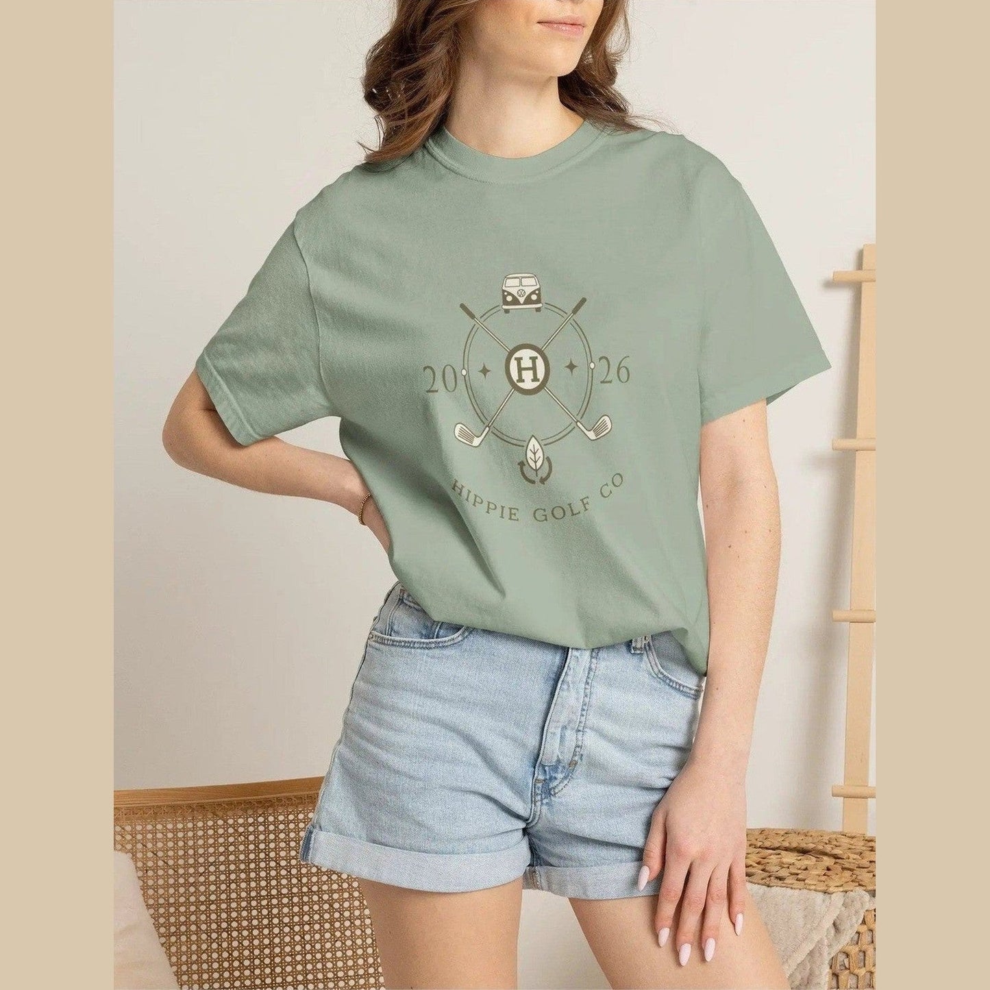 Sage green unisex t-shirt on model highlighting relaxed silhouette and front logo
