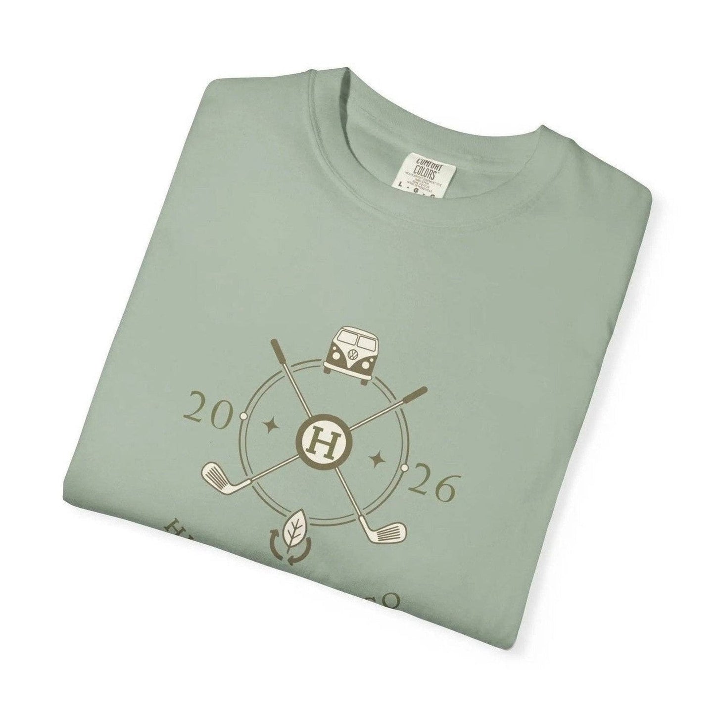 Folded sage green t-shirt displaying eco-friendly cotton tag and retro golf graphic