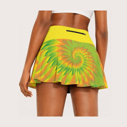 A woman wearing a bright yellow athletic skirt with a green, yellow, and orange spiral pattern on the lower half, shown from the back against a light gray studio background.