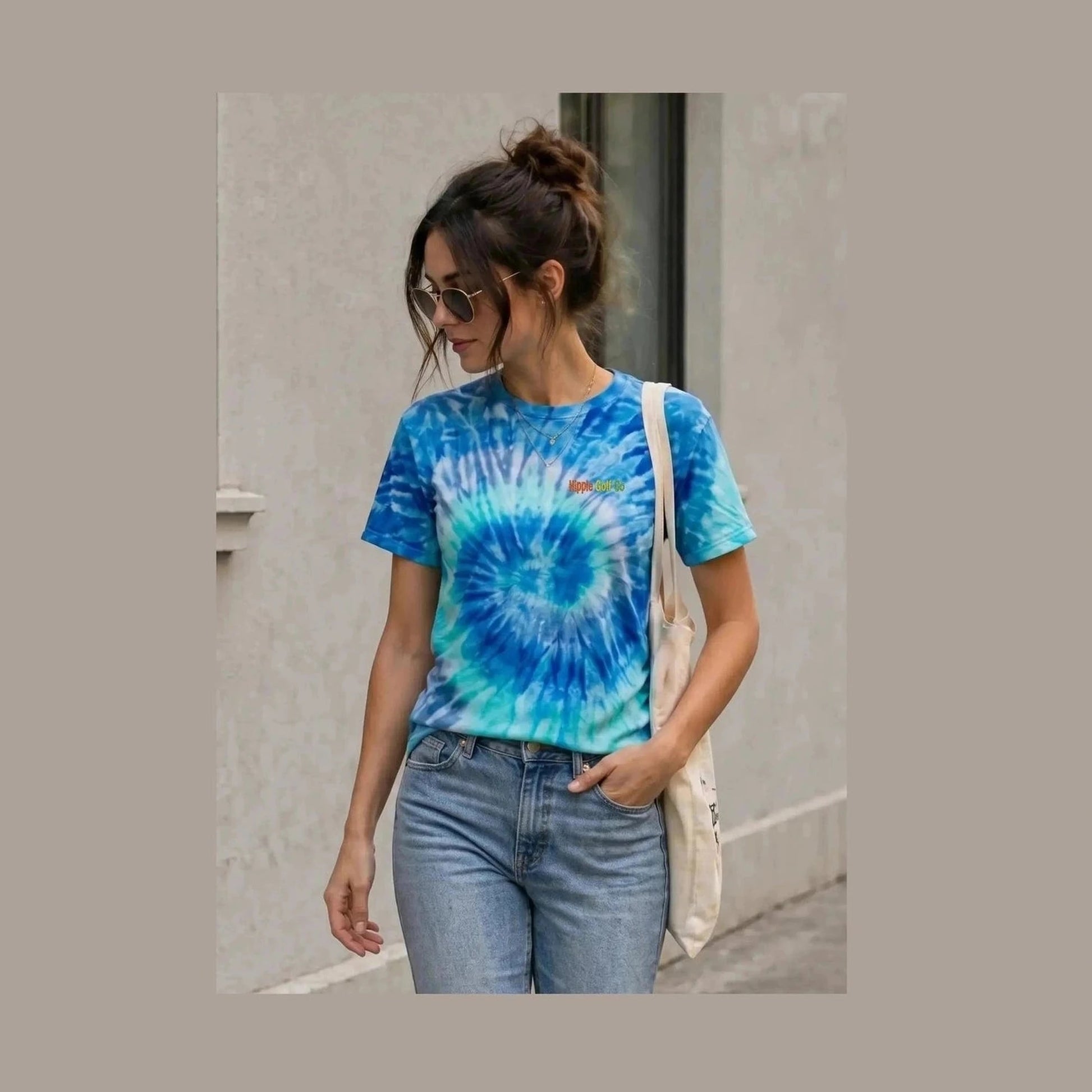 Woman modeling blue teal spiral tie-dye t-shirt with brand embroidery