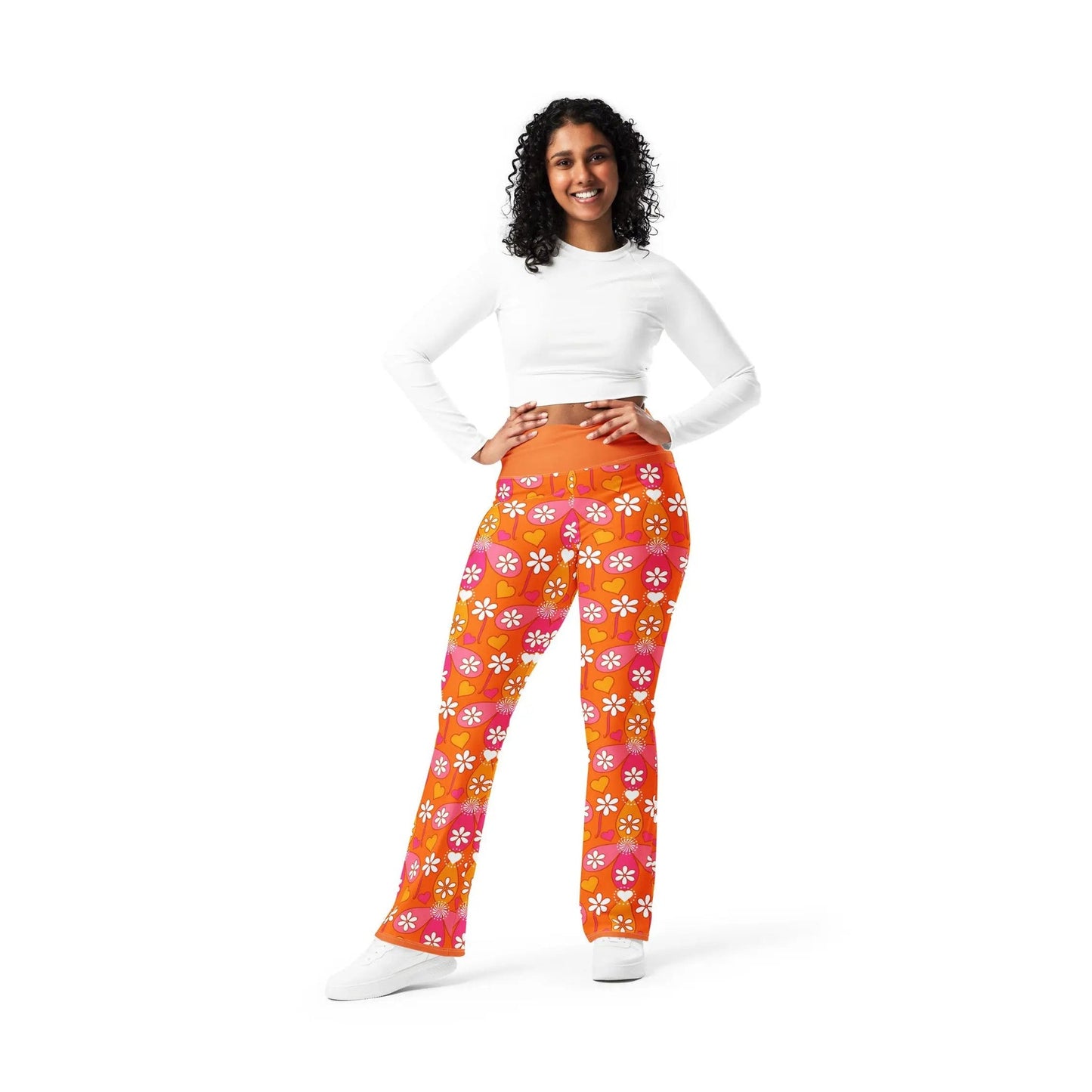 Front view of woman in orange high-rise heart print flare leggings