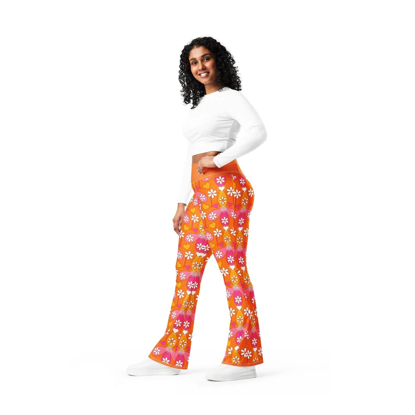 Smiling model wearing orange high-waisted flared workout pants