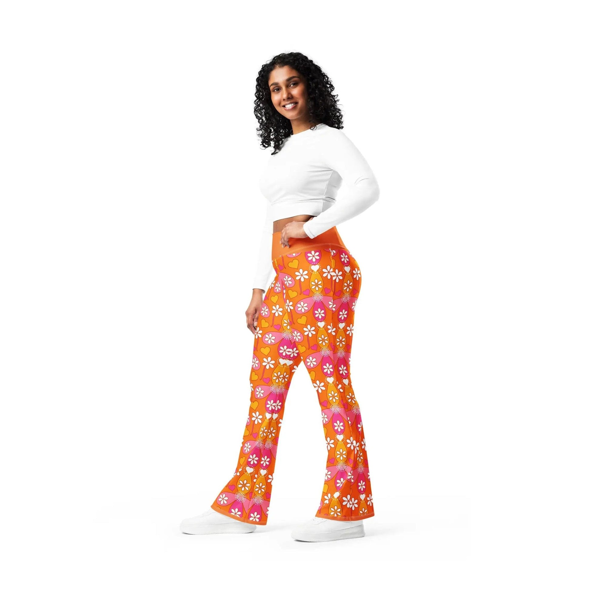 Smiling model wearing orange high-waisted flared workout pants