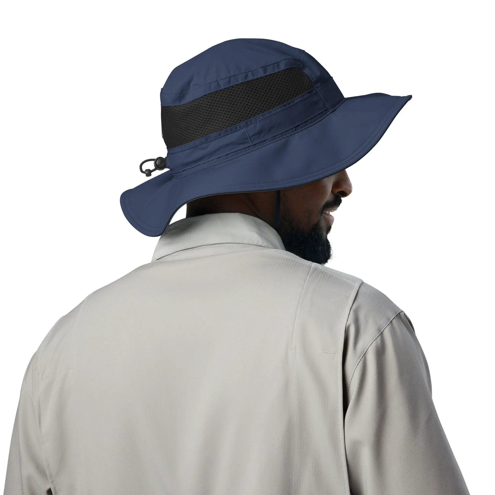 Man in beige shirt wearing navy booney hat with wide brim and black mesh side panel