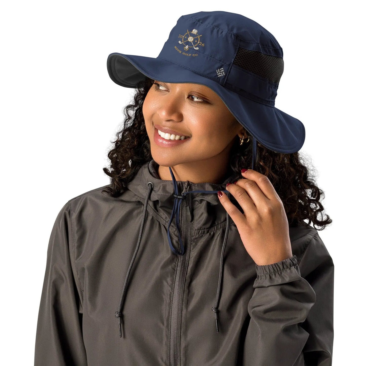 Woman adjusting navy booney hat fit with drawcord toggle and side mesh ventilation panel
