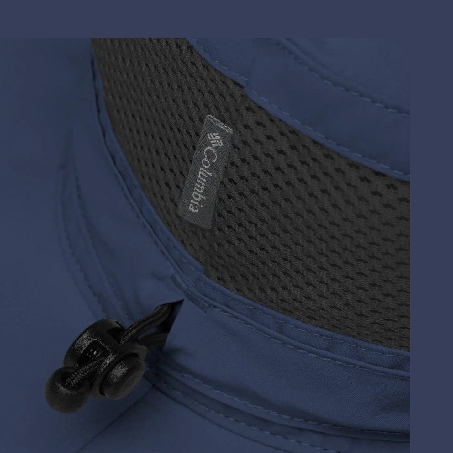 Close-up of navy booney hat interior lining with black mesh panel and Columbia brand tag